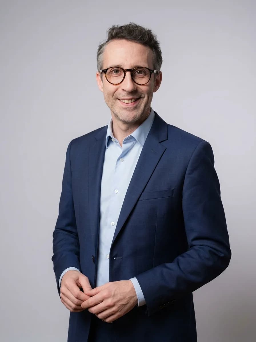 Portrait IA dentiste style corporate classique - variante costume bleu marine sans cravate, chemise bleu clair ouverte, fond studio neutre
